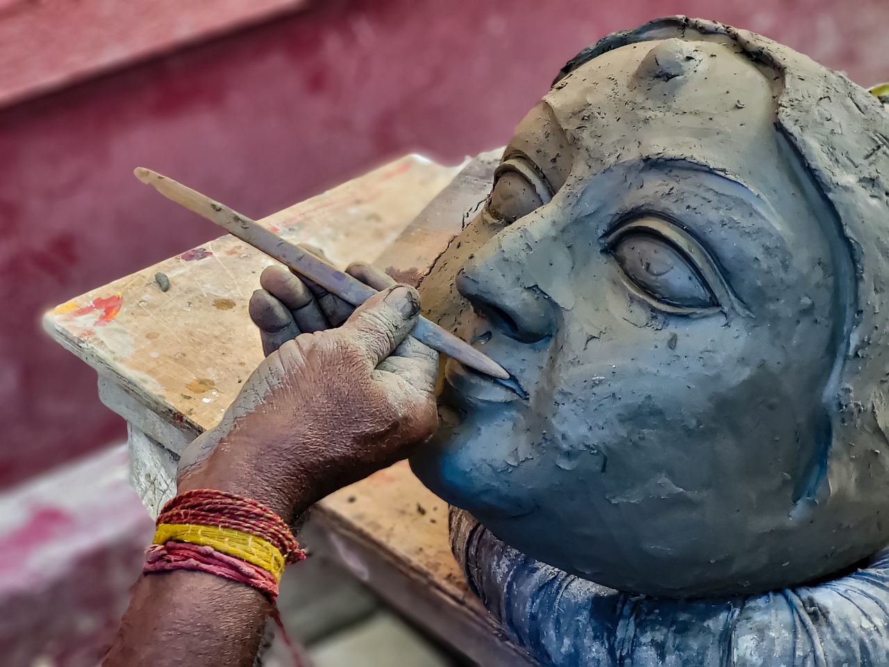 social-feed-img-04 Close-up of a sculptor working on a clay face with tools in Kolkata, India.