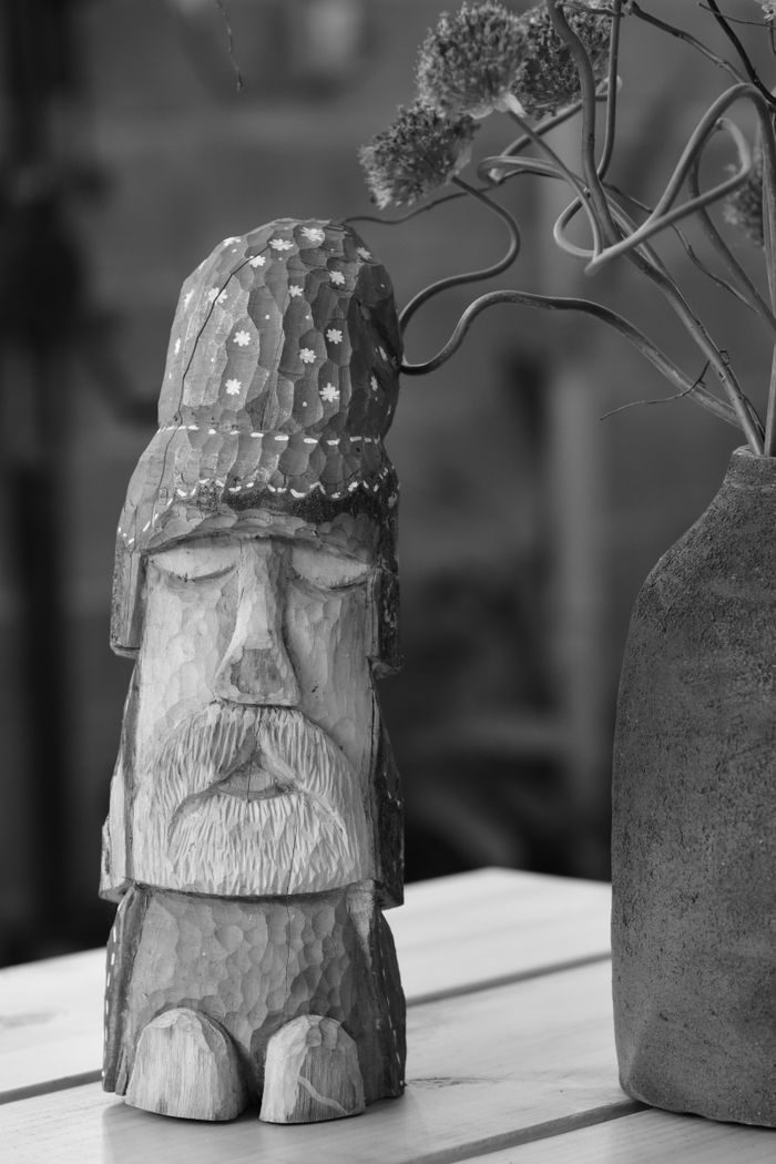 social-feed-img-05 Black and white photo of a wooden sculpture and vase, adding a rustic and artistic touch.