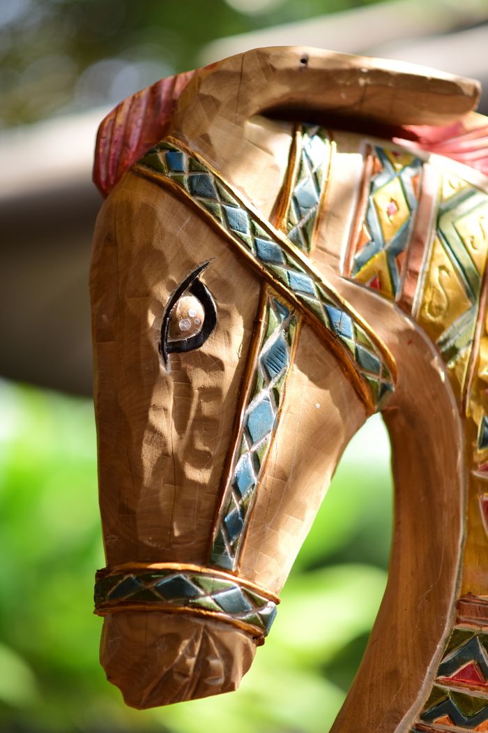social-feed-img-03 Close-up of a detailed wooden horse sculpture with colorful patterns.