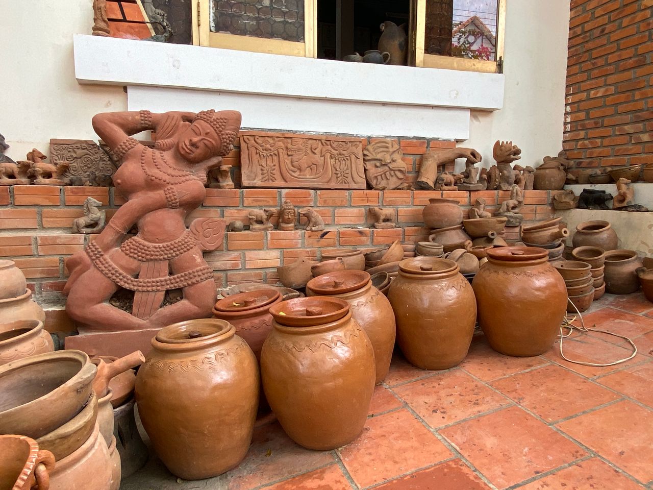 social-feed-img-05 A rich collection of traditional terracotta pottery and ornate sculptures in an outdoor setting.