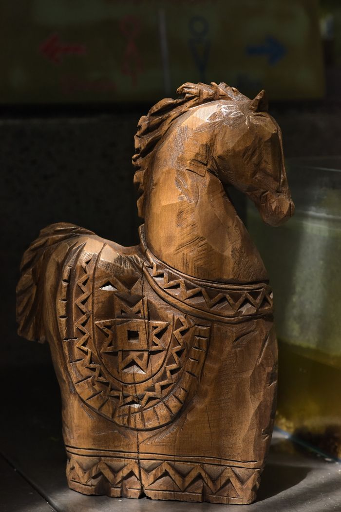 Mastering the First Impression: Your intriguing post title goes here Detailed wooden horse sculpture with intricate carvings, captured in a cozy indoor setting.