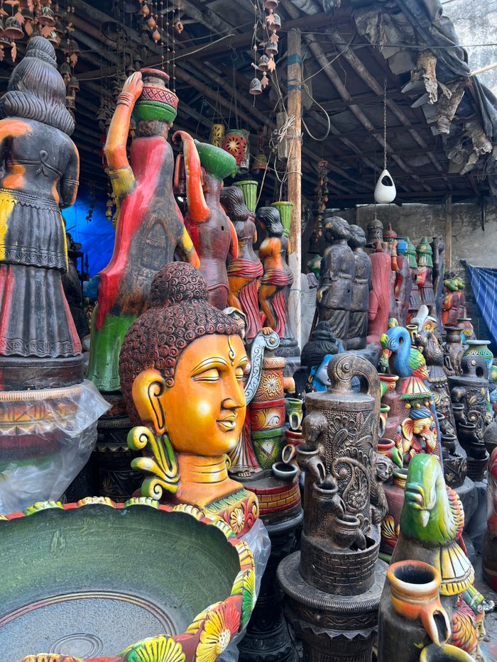 Crafting Captivating Headlines: Your awesome post title goes here Vibrant display of traditional Indian pottery and Buddha statues in a marketplace setting.
